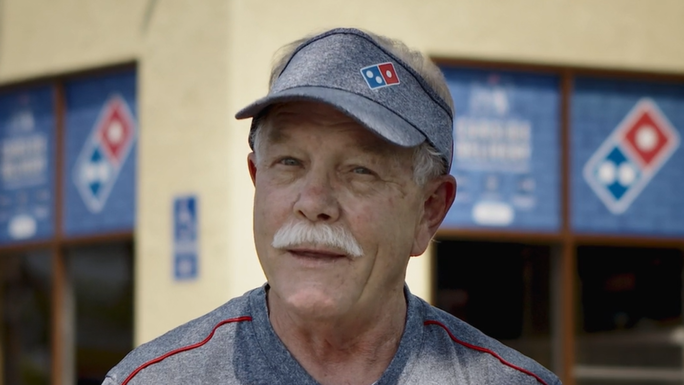 a man with a mustache wearing a baseball cap