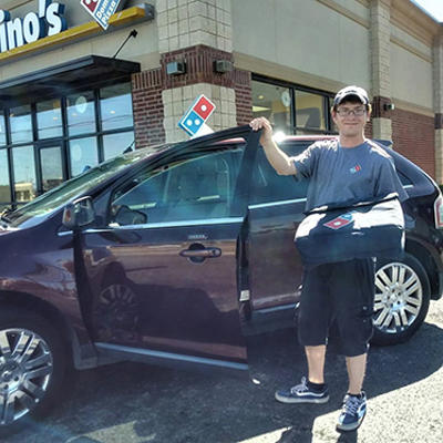 a man holding a bag and standing next to a car