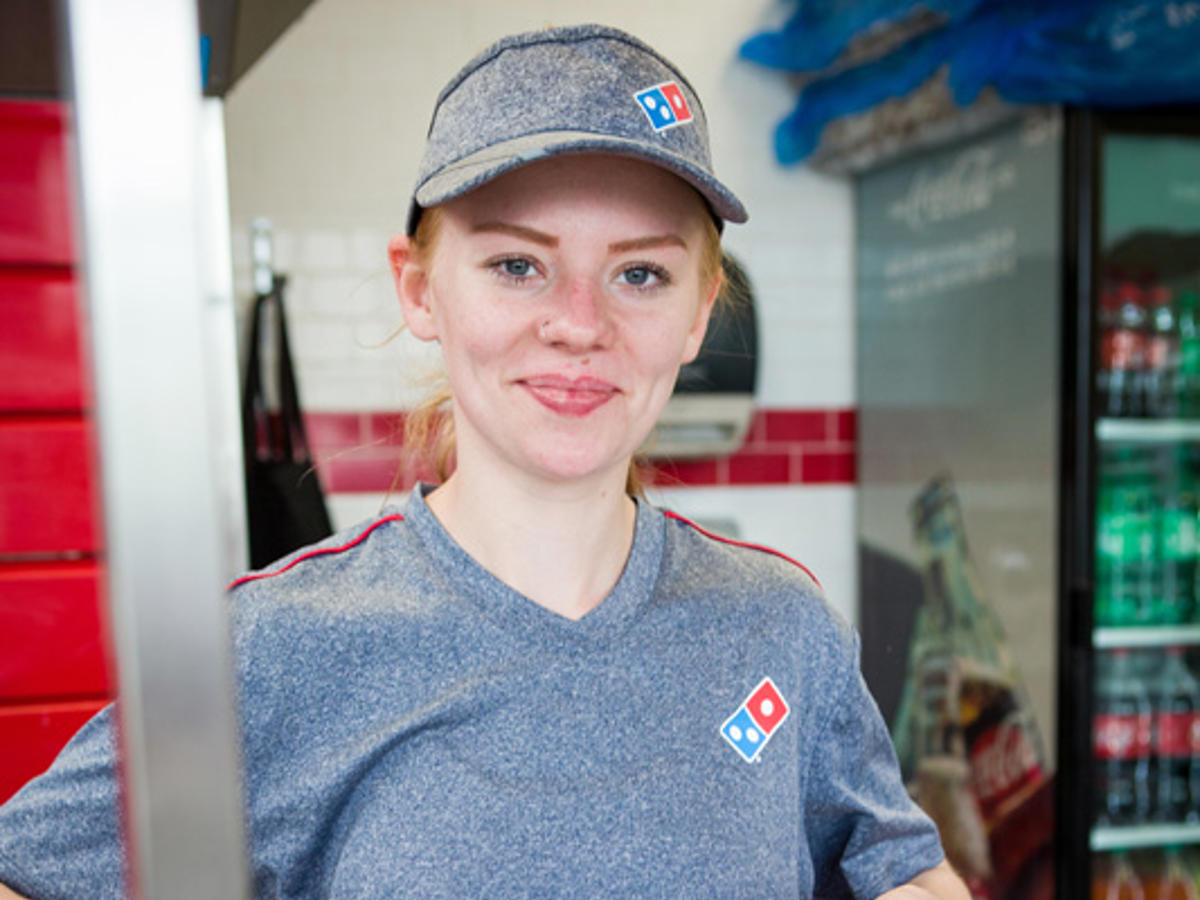 a woman holding a pizza box