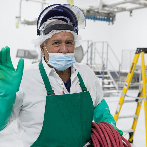 a man wearing a mask and green apron