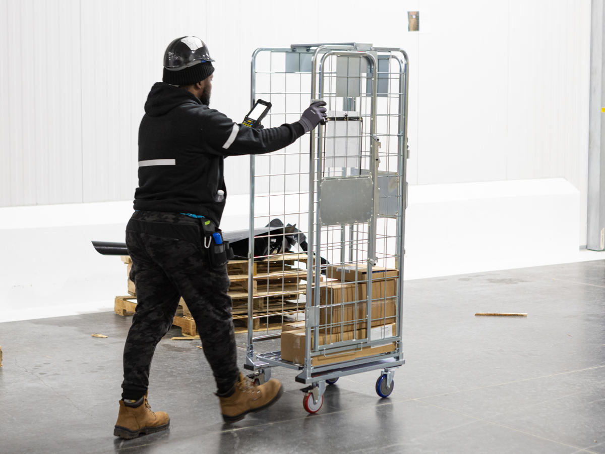 a man pushing a cart with a cell phone