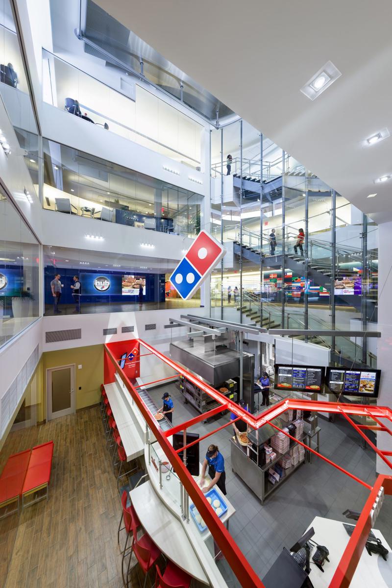 a large building with glass walls and a red and white sign