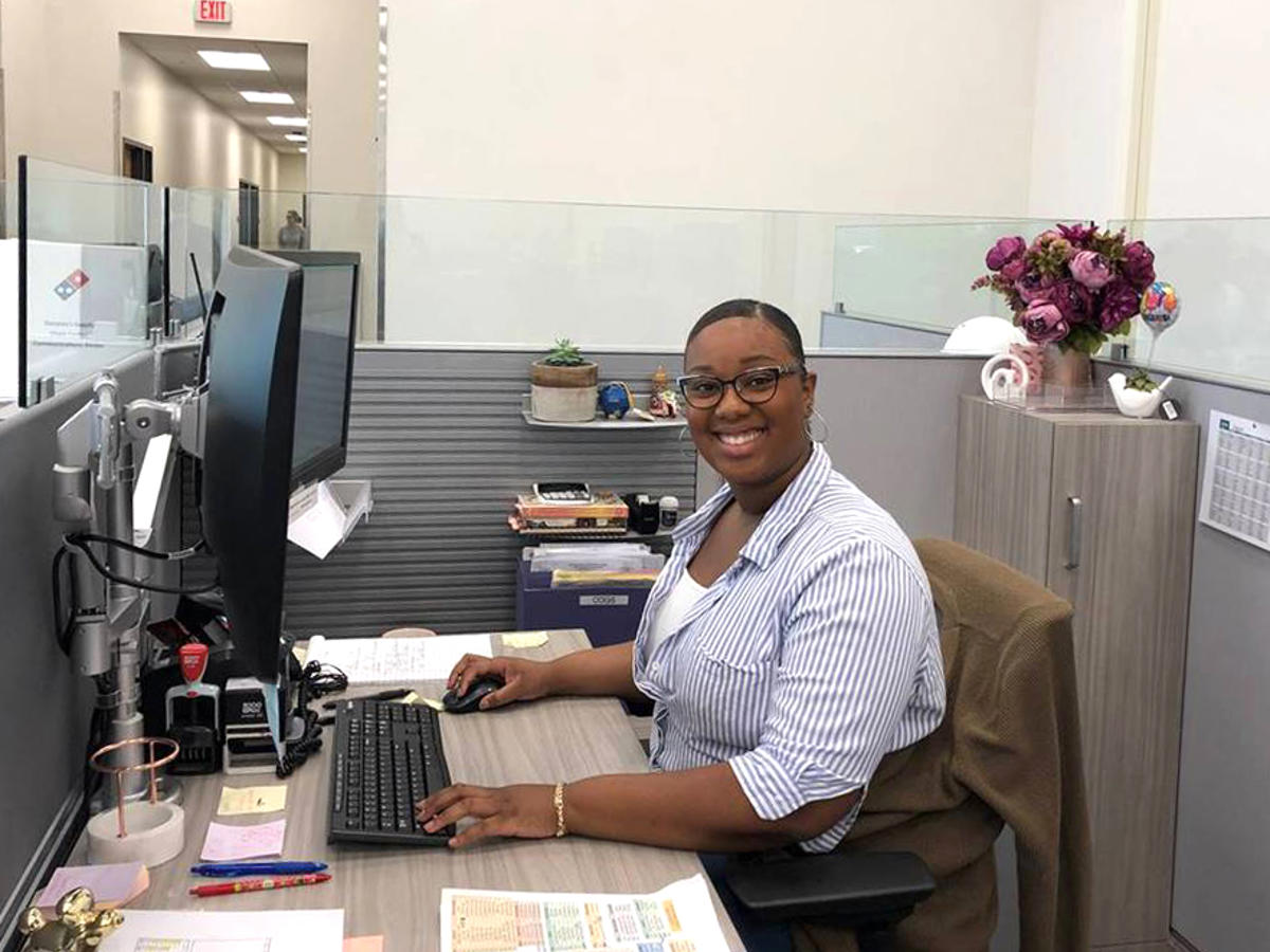 a woman sitting at a desk smiling